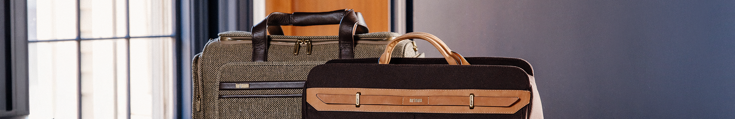 Banner image is of the Tweed Travel Duffel and Reserve Weekender Duffel. Scroll down below to shop all the different types of totes, duffels, and slings that Hartmann has to offer.